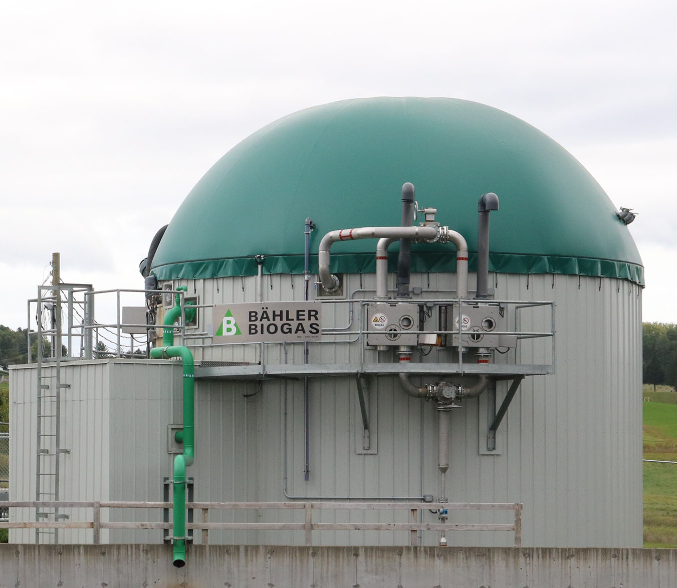 Gros plan du biodigesteur construit au Centre de recherche et de développement de Sherbrooke. Un bâtiment en forme de tour ronde, plus bas et plus large qu’un silo à grains.