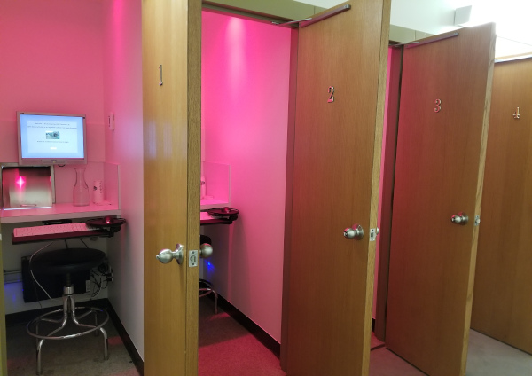 A row of sensory evaluation panel rooms, each with a chair, desk, computer and slot in which samples are received for testing