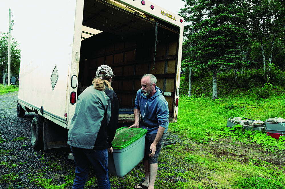 Ben Wiper and a team member load a container into a truck