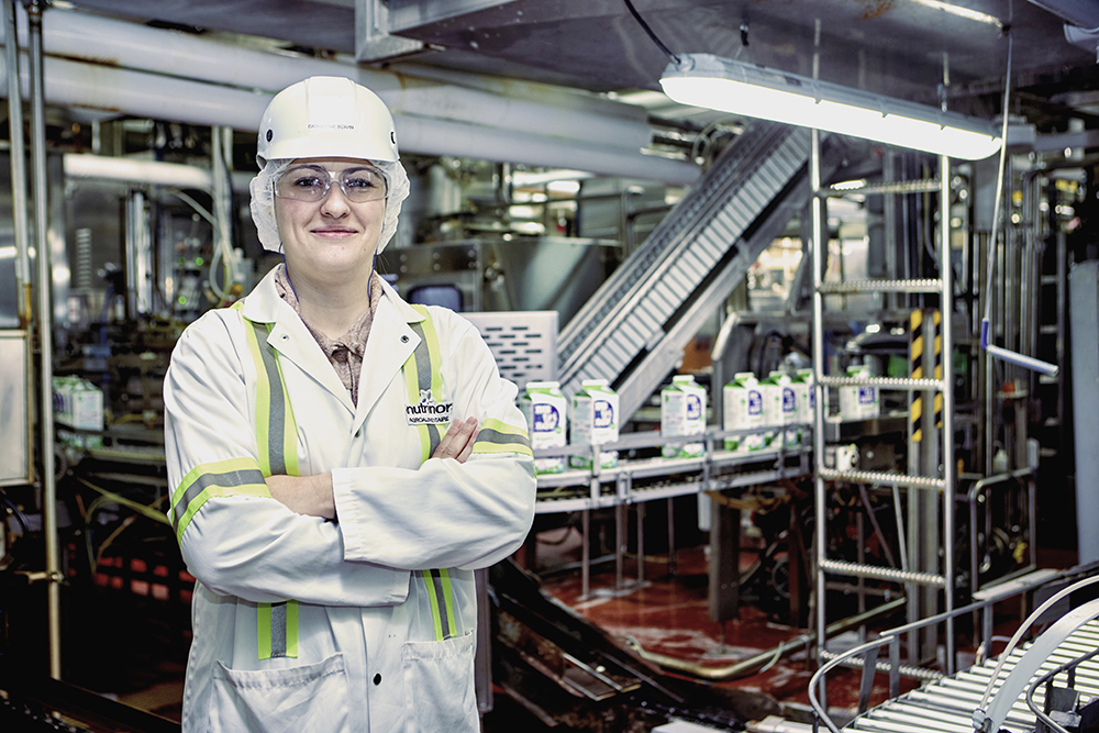  A woman stands in front of the milk packaging equipment at the Nutrinor factory