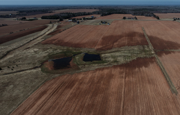 Deux milieux humides construits côte à côte, entourés de verdure et de champs agricoles.