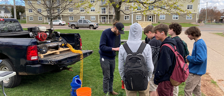 A group of students watching a demonstration.