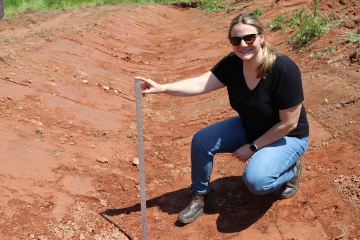 Dr. Murray’s research technician, Jenn Klaus, is pictured crouched beside a measuring stick in a mini wetland. 