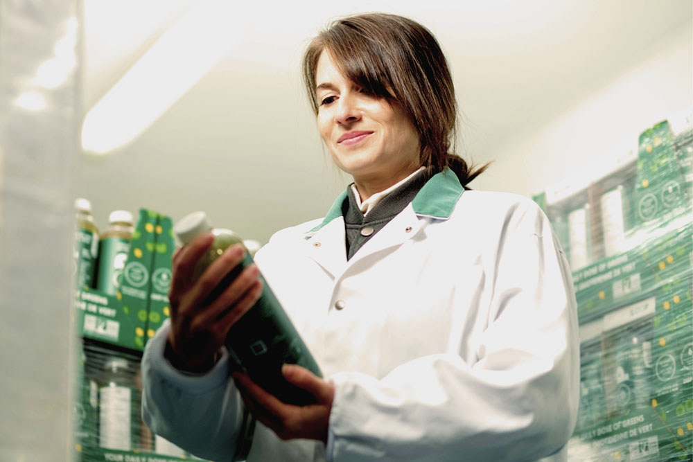 Julie in a lab coat examining a LOOP juice