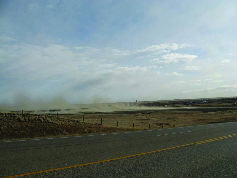 Image displays the Primary particulate matter resulting from wind erosion, dust blowing towards a highway.