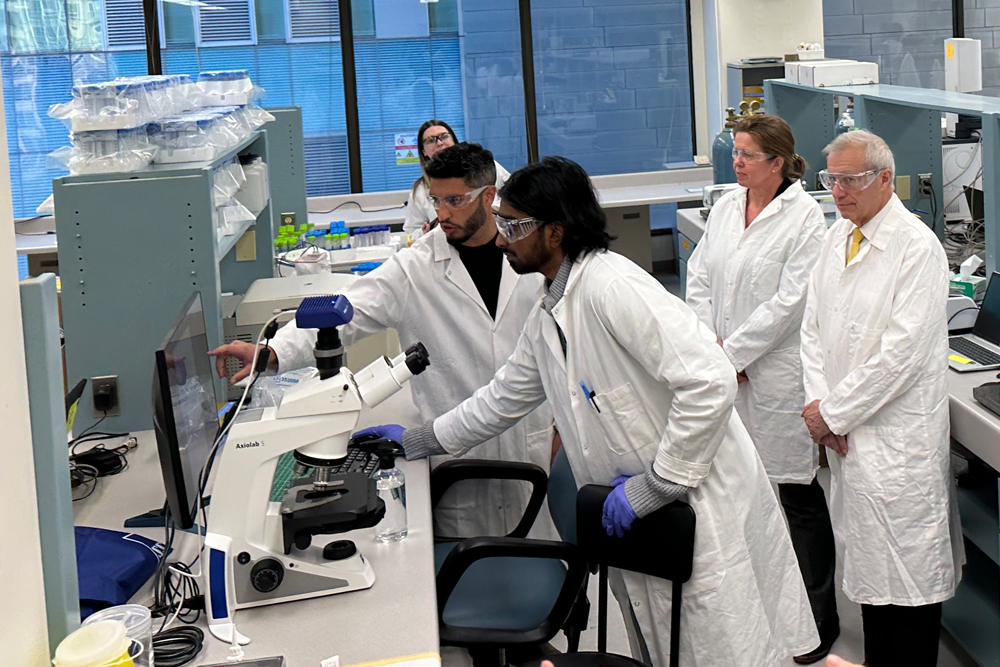 Un groupe de personnes en blouse de laboratoire travaillant dans un laboratoire